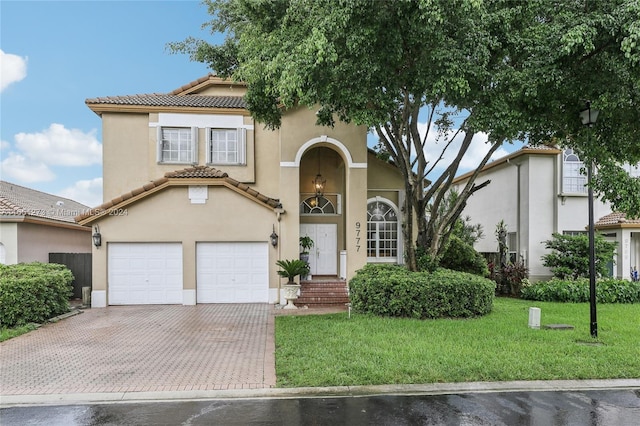 mediterranean / spanish-style home featuring a garage and a front lawn