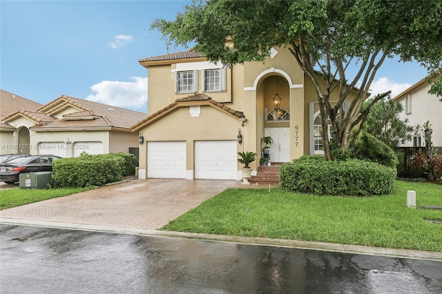 mediterranean / spanish-style house featuring a garage and a front lawn