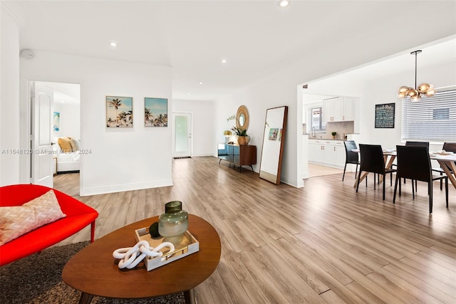 living room with light hardwood / wood-style flooring and a notable chandelier