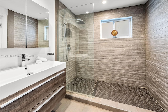 bathroom with tile patterned floors, tiled shower, and vanity