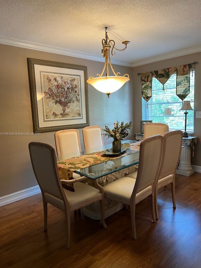dining room featuring ornamental molding, a textured ceiling, wood finished floors, and baseboards