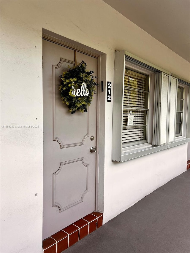 property entrance with stucco siding