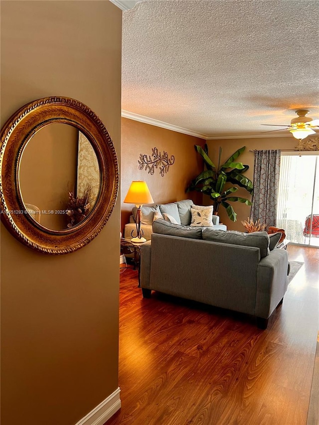 living room featuring hardwood / wood-style floors, a textured ceiling, ceiling fan, and crown molding