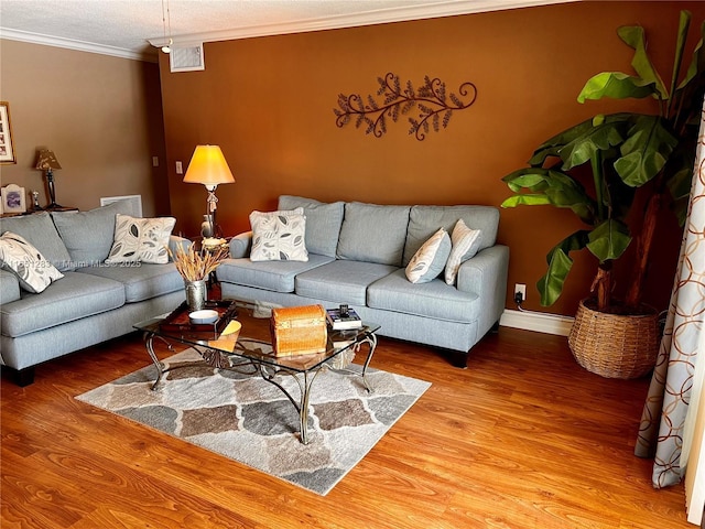 living room with crown molding, wood-type flooring, and a textured ceiling