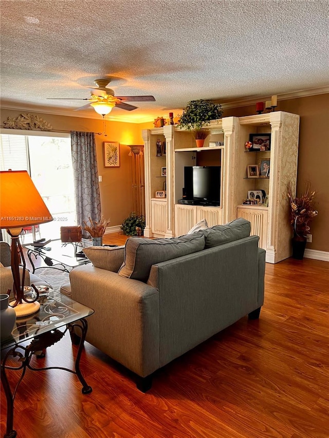 living room featuring hardwood / wood-style flooring, ceiling fan, crown molding, and a textured ceiling