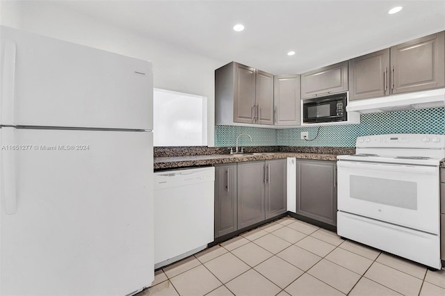 kitchen featuring gray cabinetry, white appliances, and decorative backsplash