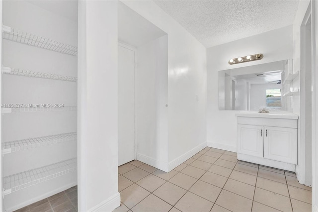 bathroom with tile patterned floors, a textured ceiling, and vanity