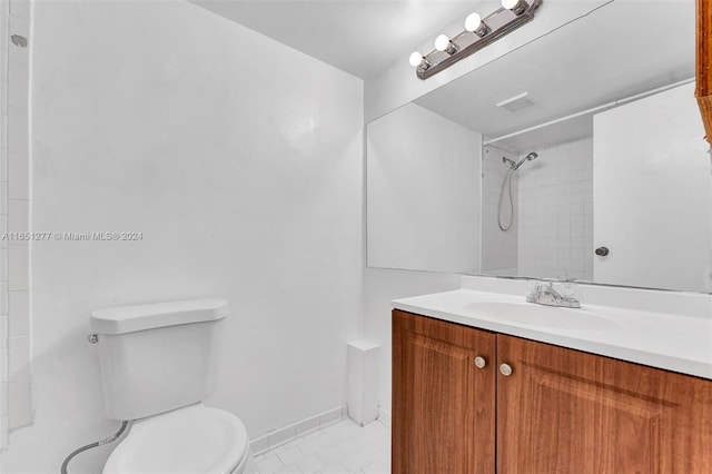 bathroom with tile patterned floors, tiled shower, toilet, and vanity