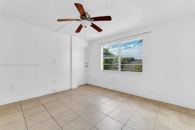 tiled spare room featuring ceiling fan and a textured ceiling