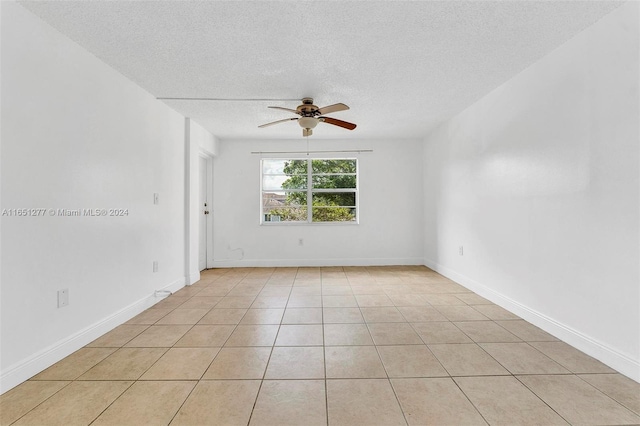 unfurnished room with a textured ceiling, light tile patterned floors, and ceiling fan