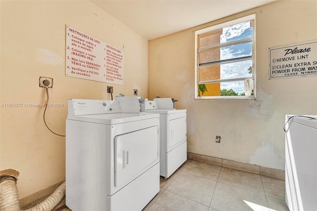 laundry area featuring washing machine and clothes dryer and light tile patterned floors