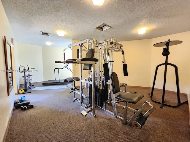 exercise area featuring a textured ceiling and carpet floors