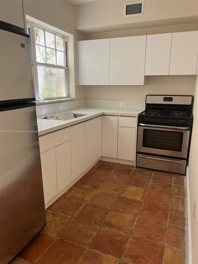 754 Meridian Ave Unit 15, Miami Beach, FL 33139 - kitchen with stainless steel appliances, light countertops, white cabinets, and stone tile flooring