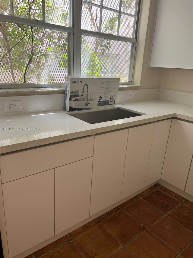 kitchen with dark tile patterned flooring and sink