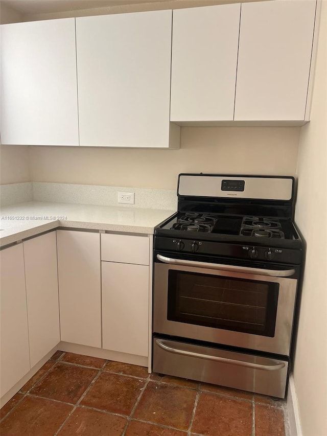 kitchen with gas range and white cabinets