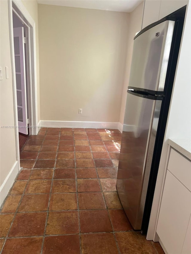754 Meridian Ave Unit 15, Miami Beach, FL 33139 - kitchen featuring freestanding refrigerator, baseboards, white cabinetry, and light countertops