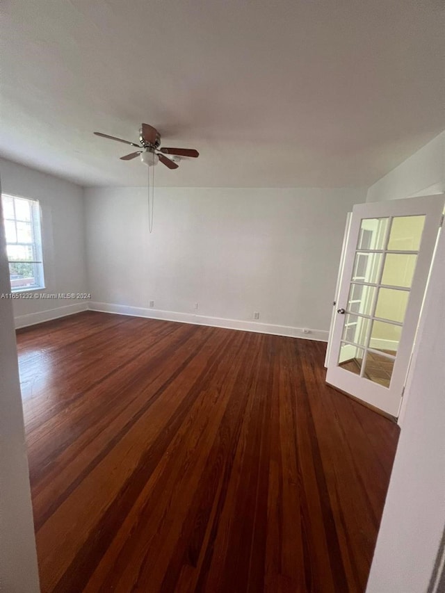 empty room with ceiling fan and dark hardwood / wood-style floors