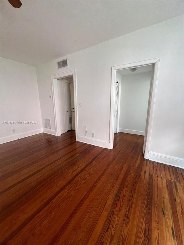 unfurnished room featuring dark wood-type flooring and ceiling fan