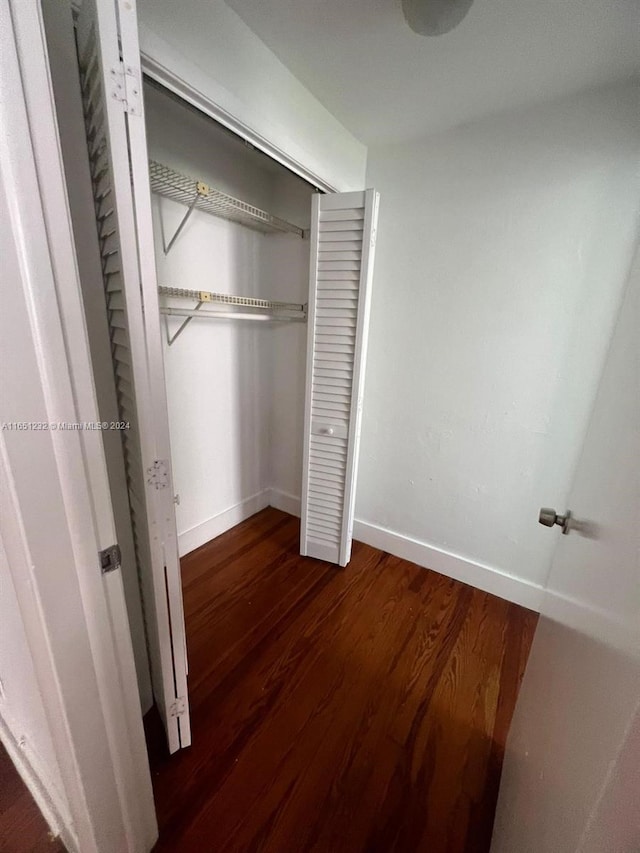 unfurnished bedroom featuring a closet and dark hardwood / wood-style floors