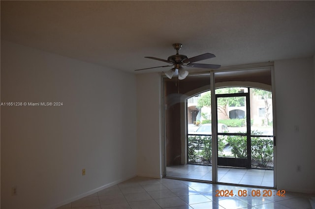 unfurnished room with ceiling fan and light tile patterned flooring