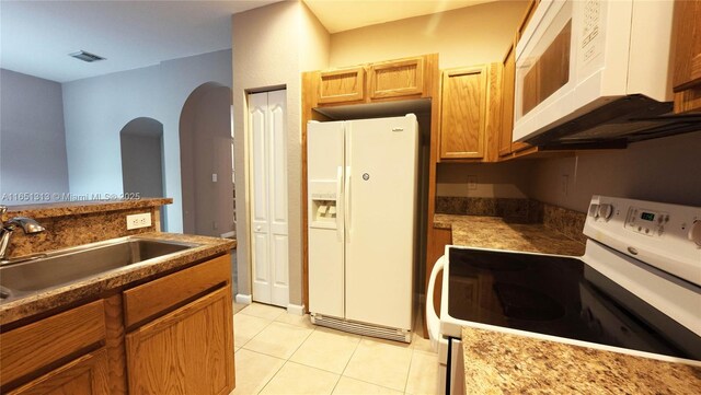 kitchen with sink, white appliances, and light tile patterned floors