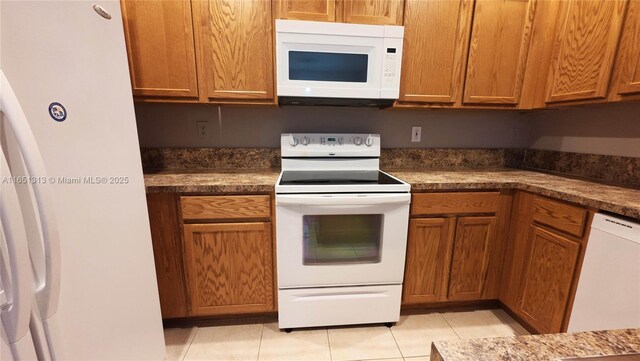 kitchen with light tile patterned floors, kitchen peninsula, dishwasher, and sink