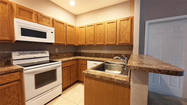 kitchen with light stone counters, white appliances, and light tile patterned flooring