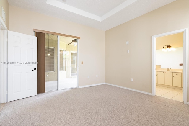 unfurnished bedroom featuring light carpet and connected bathroom