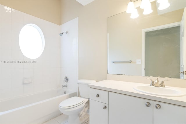 full bathroom with tiled shower / bath, vanity, toilet, and tile patterned floors