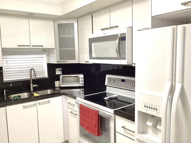 kitchen with electric stove, white cabinetry, and white refrigerator with ice dispenser