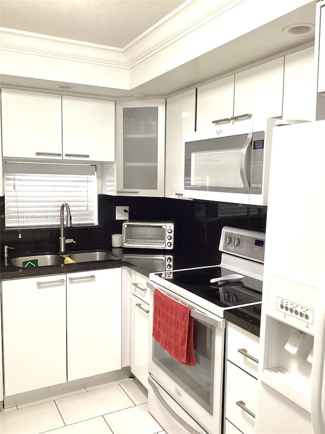 kitchen featuring light tile patterned flooring, white cabinets, white appliances, crown molding, and sink