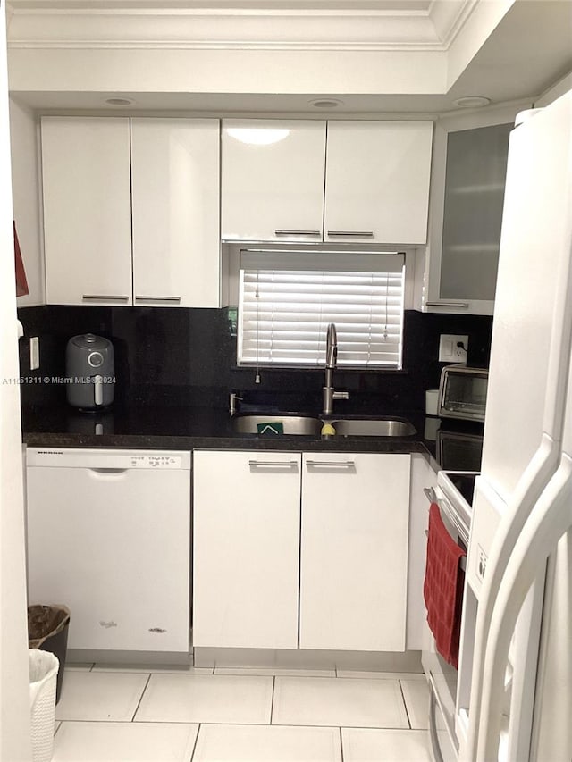 kitchen featuring sink, white cabinets, white appliances, light tile patterned floors, and crown molding