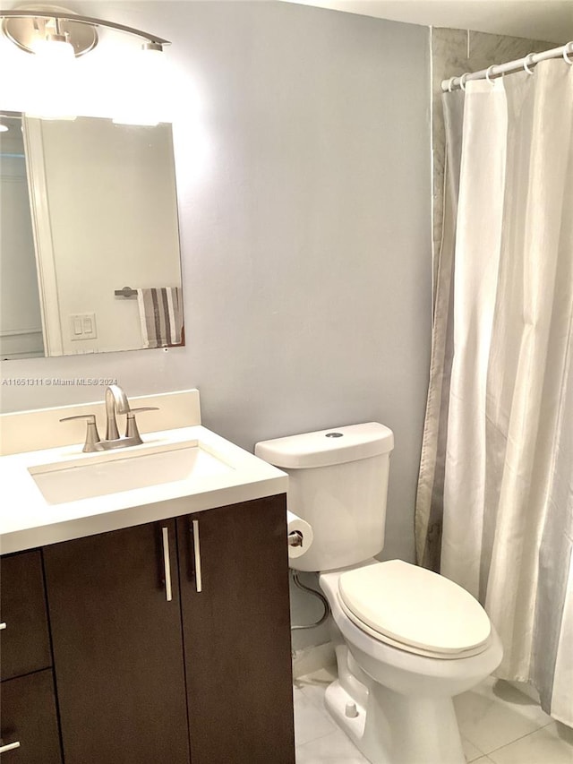 bathroom with walk in shower, vanity, tile patterned flooring, and toilet