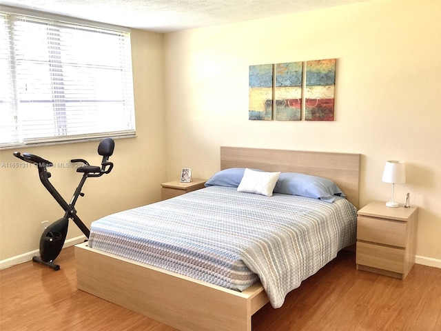 bedroom with a textured ceiling and hardwood / wood-style floors