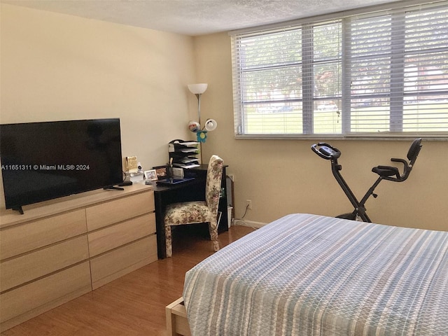 bedroom with a textured ceiling and dark hardwood / wood-style floors