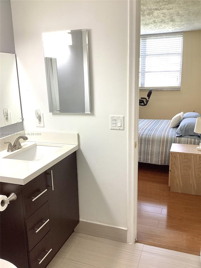 611 S Hollybrook Dr Unit 102, Pembroke Pines, FL 33025 - bathroom with vanity, ensuite bath, baseboards, and wood finished floors