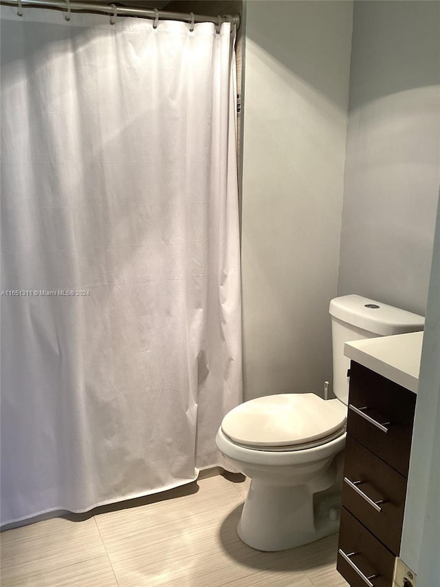 bathroom featuring walk in shower, vanity, and toilet