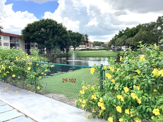 view of property's community featuring a lawn and a water view