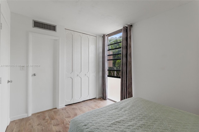 bedroom with light wood-type flooring and a closet