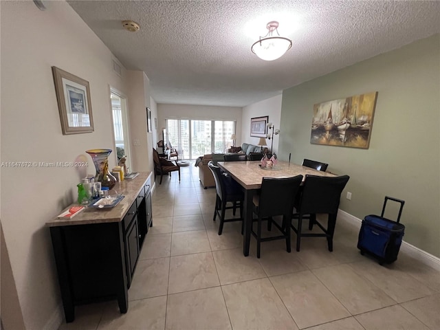 tiled dining area featuring a textured ceiling