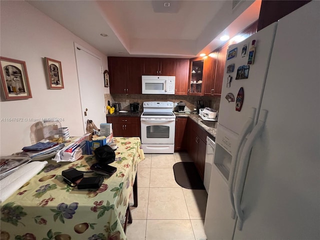 kitchen featuring tasteful backsplash, white appliances, and light tile patterned flooring