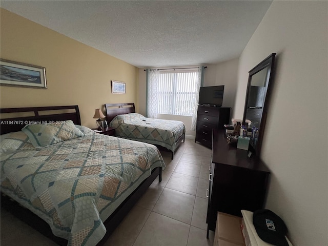 bedroom with light tile patterned floors and a textured ceiling