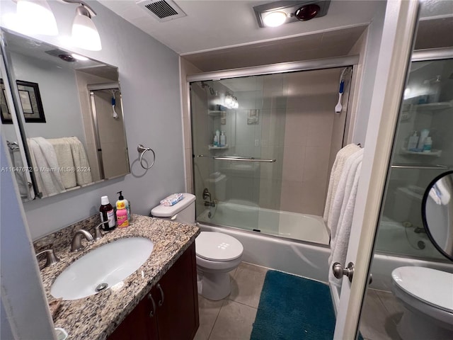 full bathroom featuring tile patterned flooring, vanity, toilet, and combined bath / shower with glass door