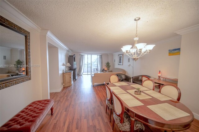 dining space with hardwood / wood-style flooring, crown molding, a chandelier, and a textured ceiling