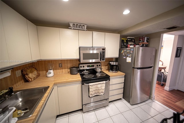 kitchen with visible vents, a sink, appliances with stainless steel finishes, white cabinets, and light countertops