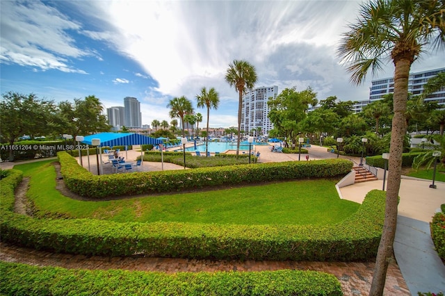 view of community featuring a lawn and a city view