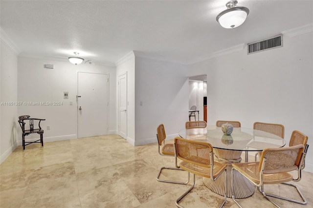 dining area featuring a textured ceiling and ornamental molding