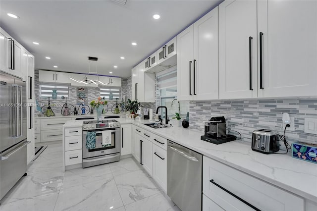 kitchen with appliances with stainless steel finishes, white cabinetry, and sink