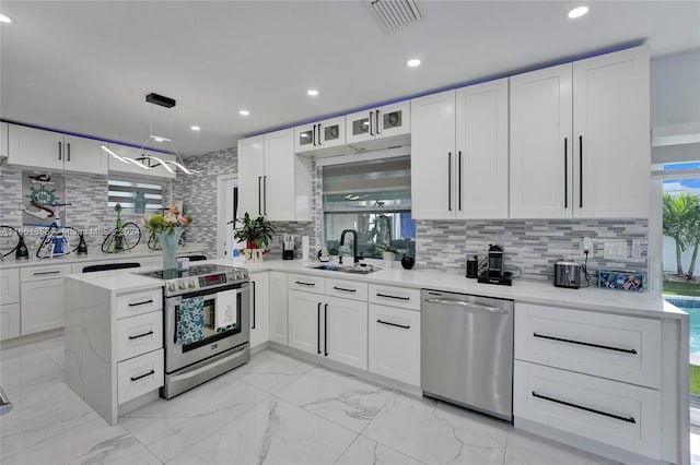 kitchen featuring appliances with stainless steel finishes, tasteful backsplash, white cabinetry, and sink