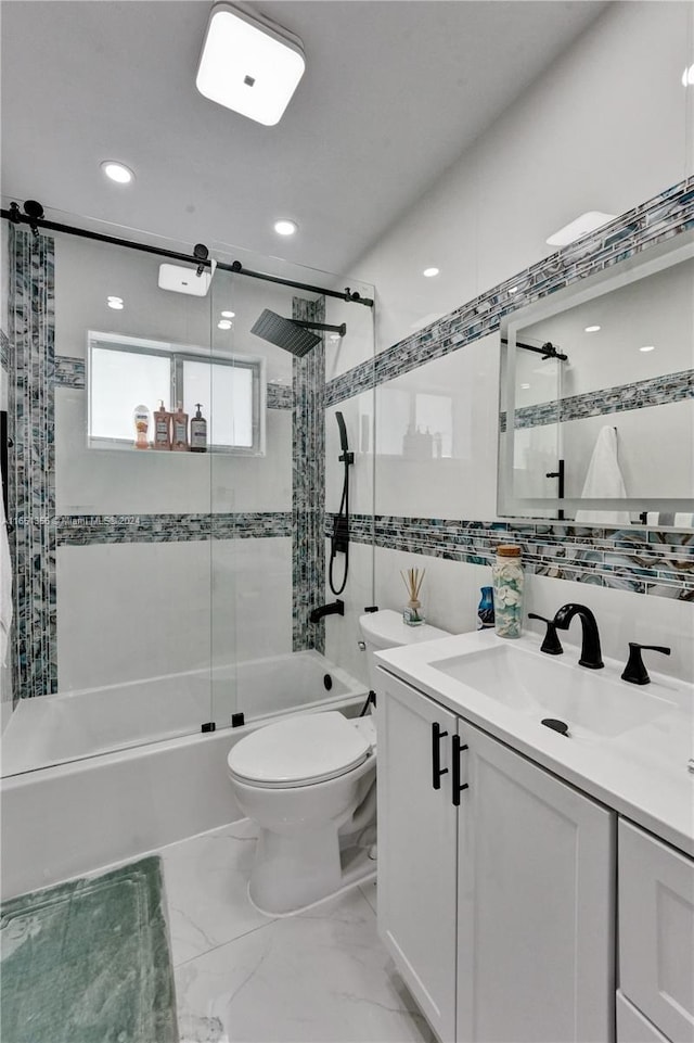 full bathroom with tile walls, toilet, bath / shower combo with glass door, and vanity